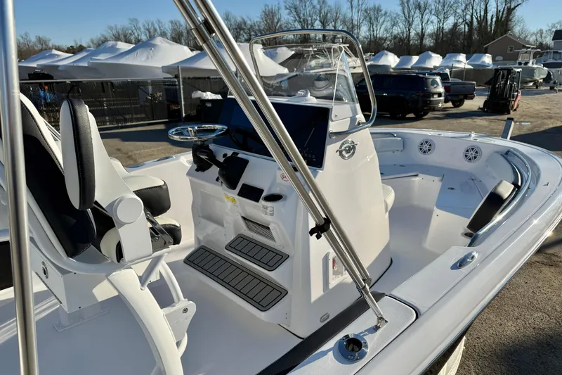 Slide: The Image of 2026 Tidewater 198 CC Adventure boat interior with console and seating, parked outdoors. - 12