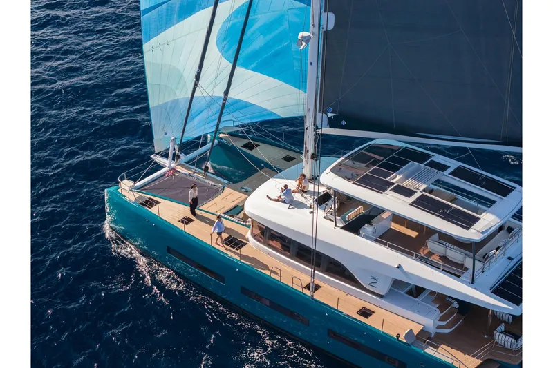 The Image of Luxurious 2026 Lagoon Eighty 2 yacht sailing on open sea with vibrant blue sails. - 0
