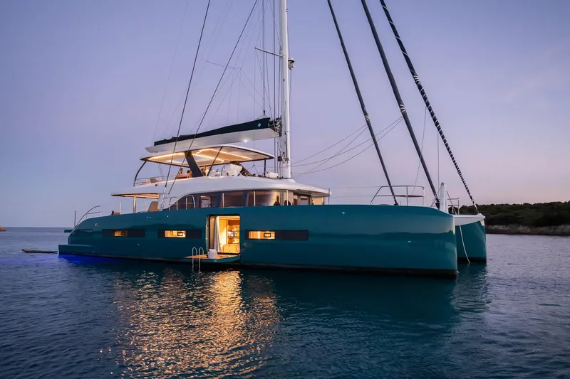 Slide: The Image of Luxurious 2026 Lagoon Eighty 2 yacht at sunset, anchored on calm waters. - 4