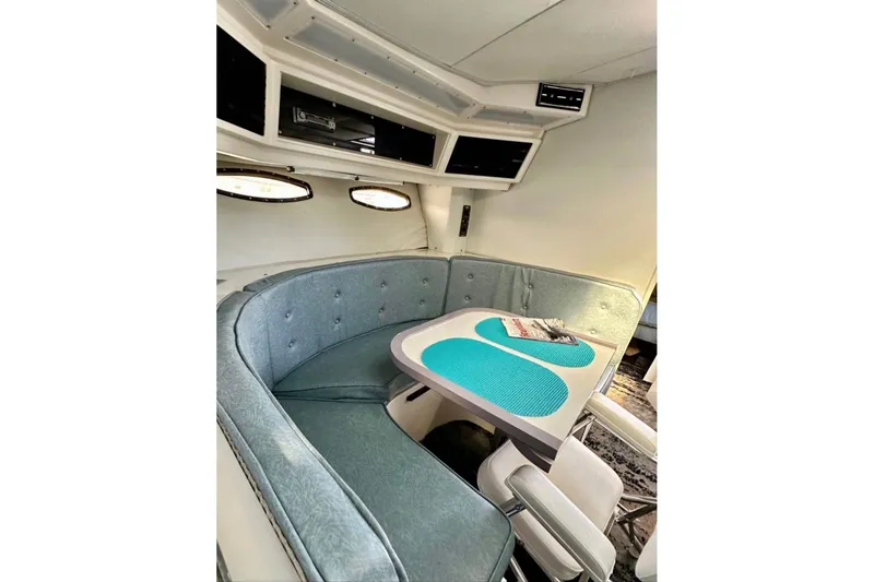 Slide: The Image of 1987 Wellcraft 3400 Gran Sport interior with teal seating and table. - 11