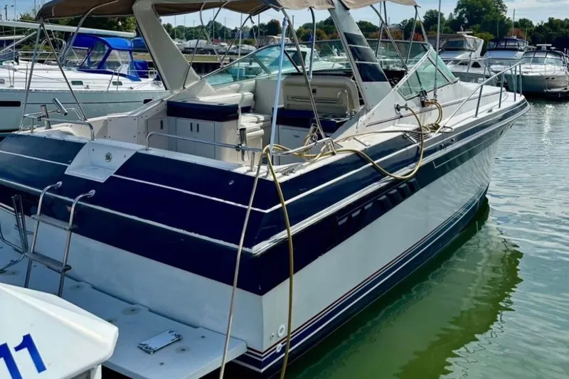 Slide: The Image of 1987 Wellcraft 3400 Gran Sport boat docked in a marina, featuring sleek design and spacious deck. - 15