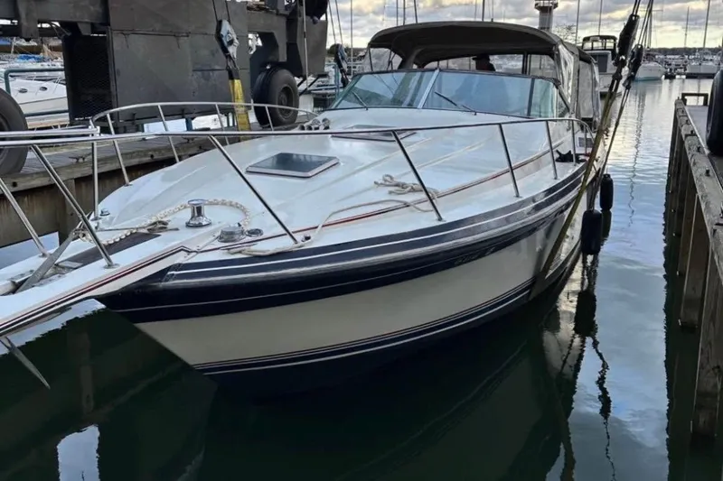 Slide: The Image of 1987 Wellcraft 3400 Gran Sport boat docked in marina, showcasing sleek design and classic style. - 5