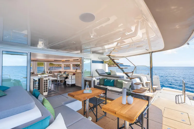 Slide: The Image of Luxurious 2025 Lagoon 60 yacht interior with ocean view, featuring modern seating and dining area. - 15