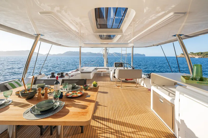 Slide: The Image of Luxurious Lagoon 60 yacht interior, 2025 model, with elegant dining setup and ocean view. - 17