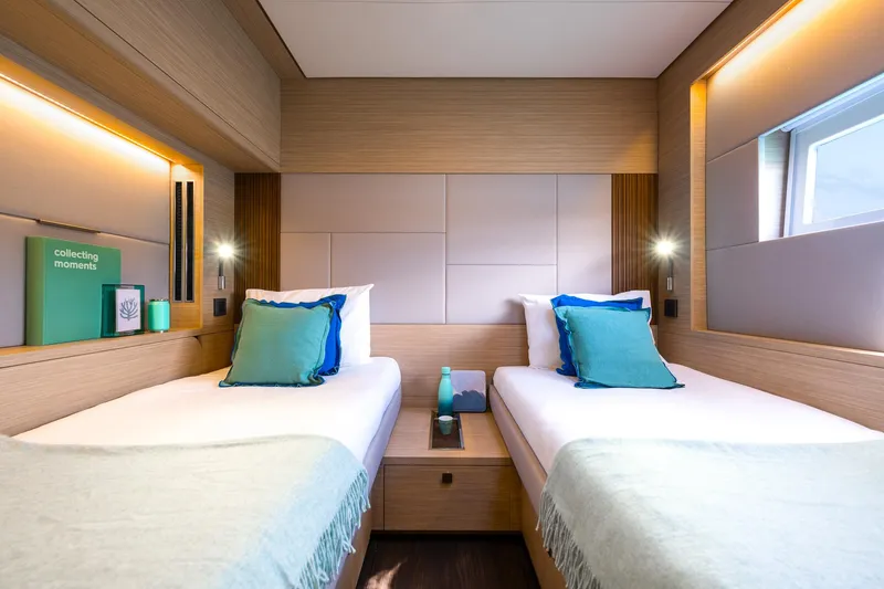 Slide: The Image of Luxurious twin cabin interior of 2025 Lagoon 60 yacht, featuring modern design and cozy bedding. - 31