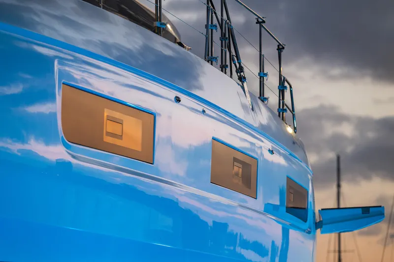 Slide: The Image of 2025 Lagoon 60 yacht with sleek blue hull and modern design features. - 7