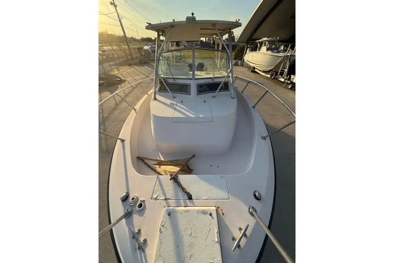 Slide: The Image of 1992 Grady White 300 Marlin boat, docked, viewed from the bow under a clear sky. - 12
