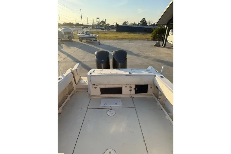 Slide: The Image of 1992 Grady White 300 Marlin boat with dual engines, docked in a sunny marina. - 6