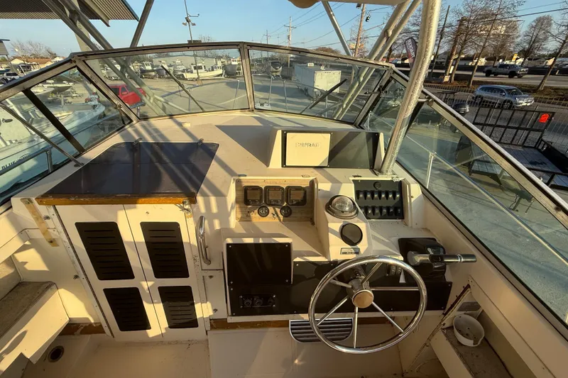 Slide: The Image of 1992 Grady White 300 Marlin boat cockpit with steering wheel and control panel. - 7