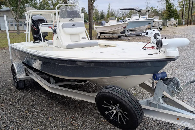 Slide: The Image of 2023 Mako 18 LTS boat on trailer, parked outdoors, featuring sleek design and modern equipment. - 2