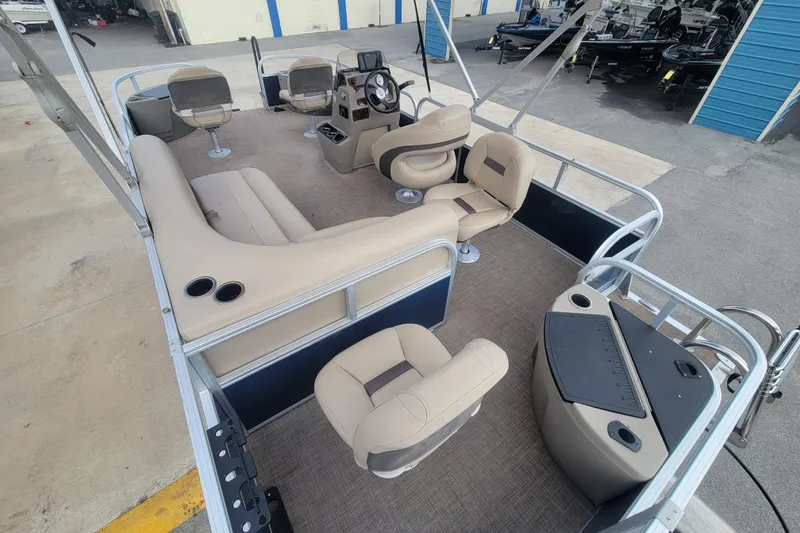 Slide: The Image of 2023 Sun Tracker Bass Buggy 18 DLX pontoon boat interior with beige seating and helm. - 13