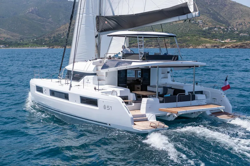 Slide: The Image of 2025 Lagoon 51 ICONIC catamaran sailing on open water, showcasing sleek design and spacious deck. - 5