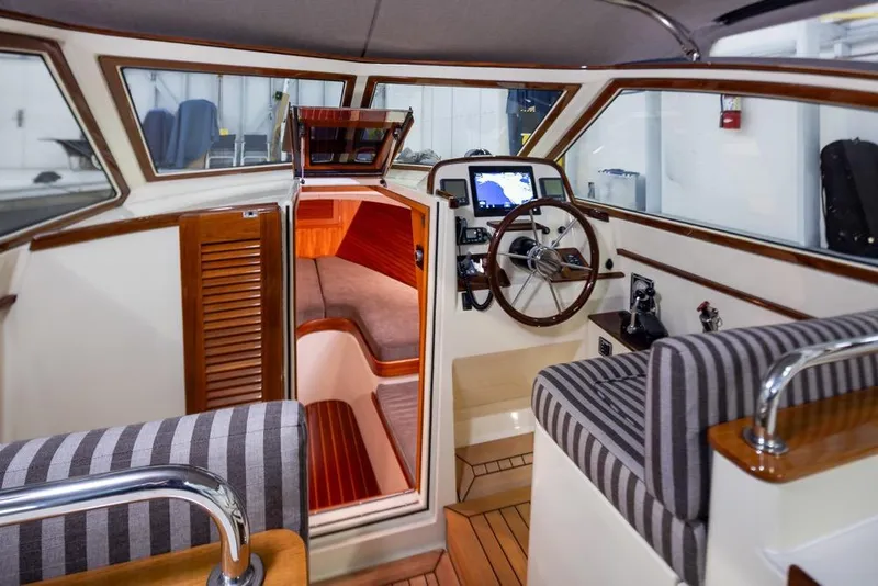Slide: The Image of Interior of 2008 San Juan 30 boat with striped seating and wooden accents. - 11