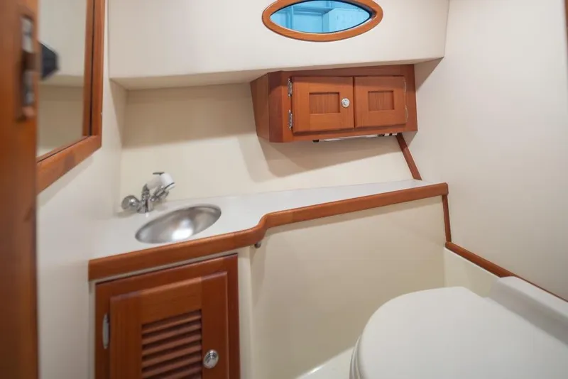 Slide: The Image of 2008 San Juan 30 yacht bathroom with sink, wooden cabinets, and toilet. - 18