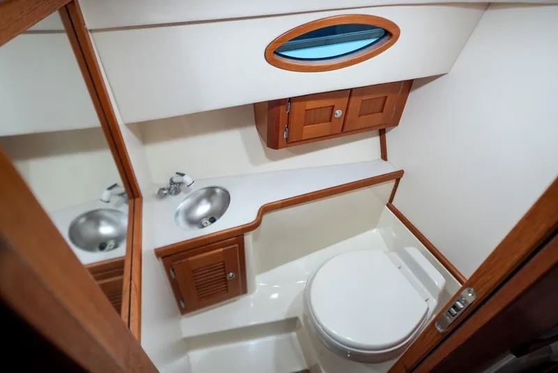 Slide: The Image of Compact bathroom in 2008 San Juan 30 boat with wooden cabinets and stainless steel sink. - 19