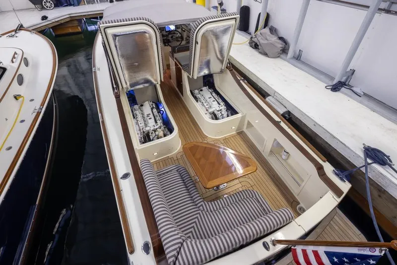 Slide: The Image of 2008 San Juan 30 boat with open engine compartments, docked indoors. - 24