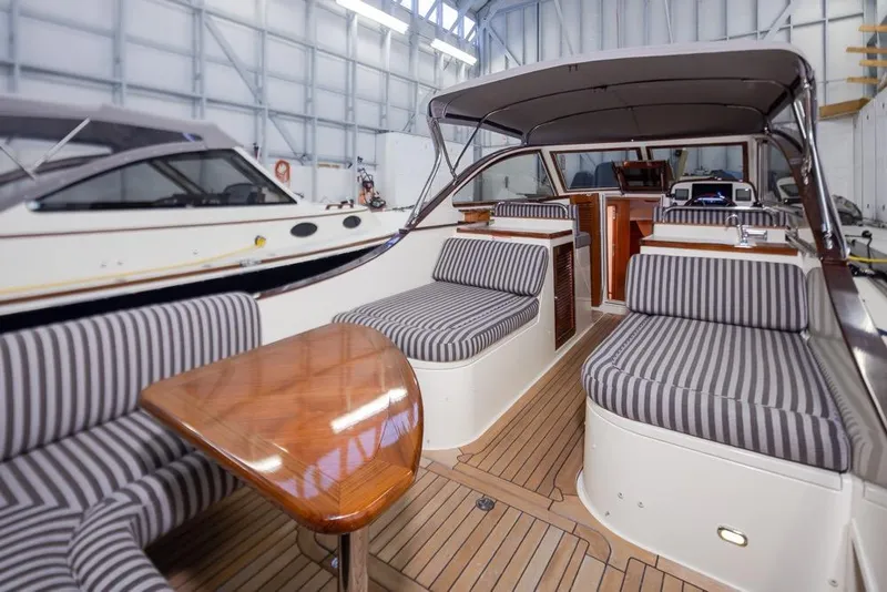Slide: The Image of Interior of a 2008 San Juan 30 boat with striped seating and wooden table. - 7