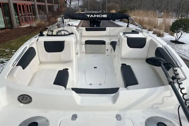 Slide: The Image of 2019 Tahoe 1950 boat interior with white and black seating, steering wheel, and outdoor setting. - 3
