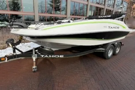 Slide: The Image of 2019 Tahoe 1950 boat on trailer, parked near modern building. - 4