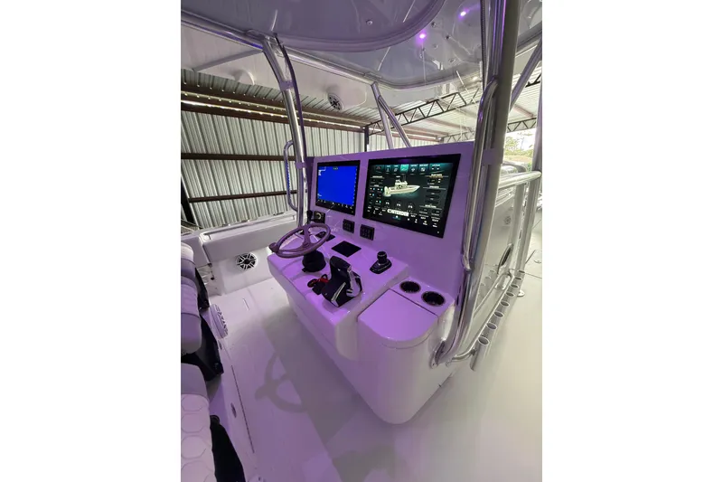 Slide: The Image of 2025 Contender 44 ST boat cockpit with advanced navigation screens and controls. - 13