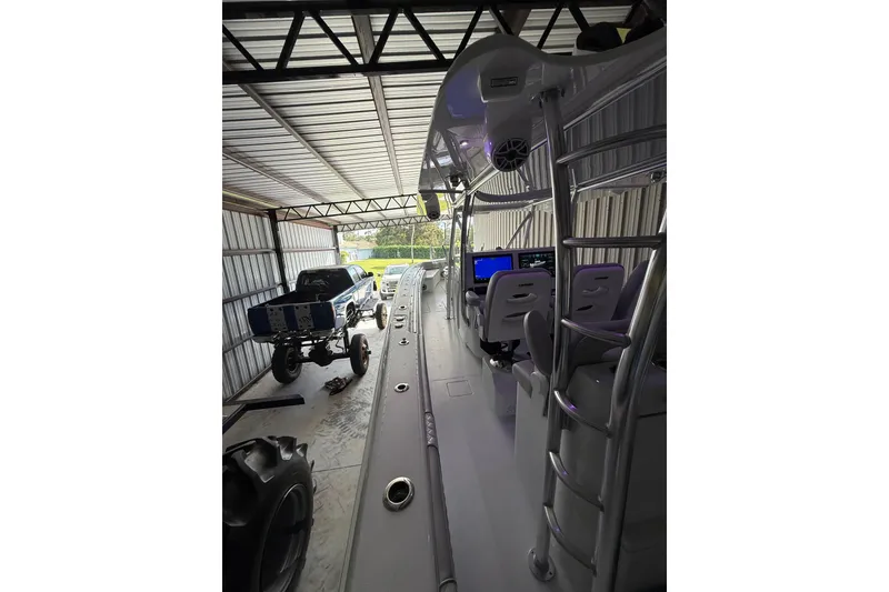 Slide: The Image of 2025 Contender 44 ST boat interior in a garage with a lifted truck nearby. - 19