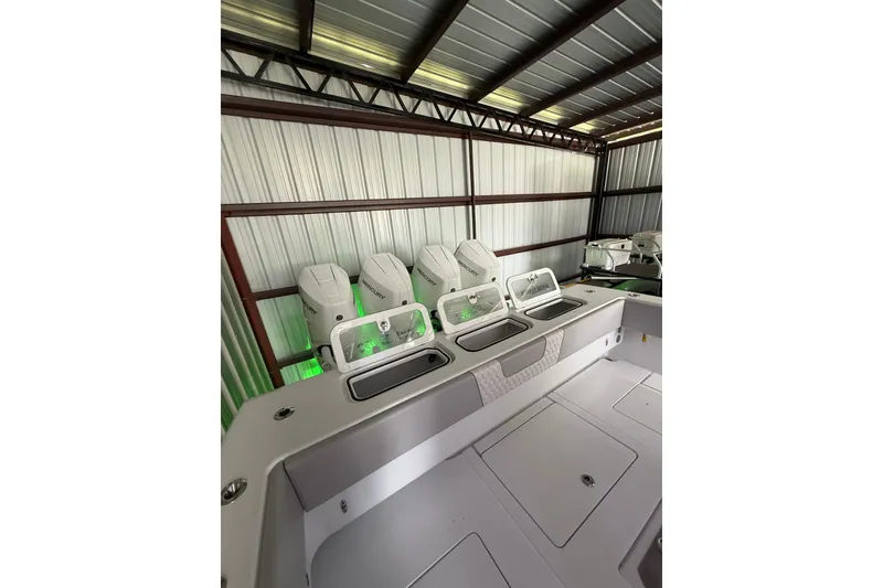 Slide: The Image of 2025 Contender 44 ST boat with multiple outboard engines in a metal storage facility. - 21