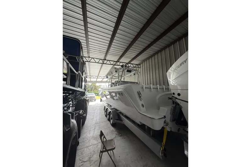 Slide: The Image of 2025 Contender 44 ST boat in storage, featuring sleek design and powerful Mercury engines. - 4