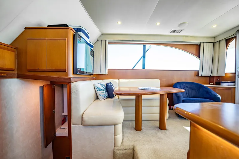 Slide: The Image of Luxurious yacht interior with wooden furnishings, cream seating, and large windows, Post 42 model, 2001. - 17