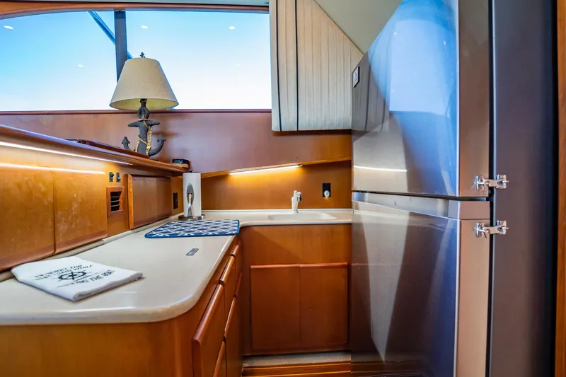 Slide: The Image of Luxurious yacht kitchen interior with wooden cabinetry, modern appliances, and nautical-themed decor. - 18