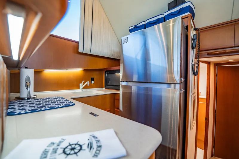 Slide: The Image of Modern yacht kitchen with stainless steel fridge, microwave, and wooden cabinetry, Post 42 model, 2001. - 19