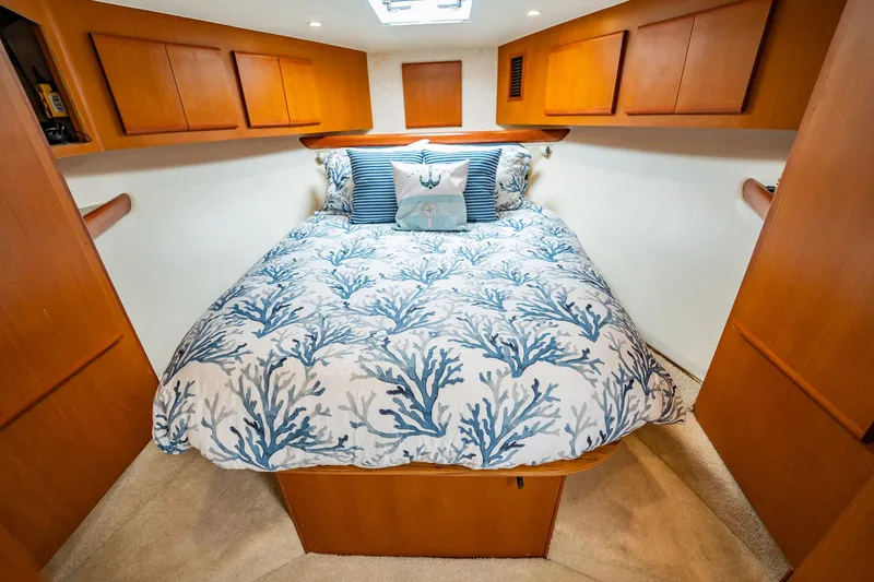 Slide: The Image of Cozy boat cabin with coral-patterned bedding, wooden cabinets, and soft lighting, Post 42 model, 2001. - 23