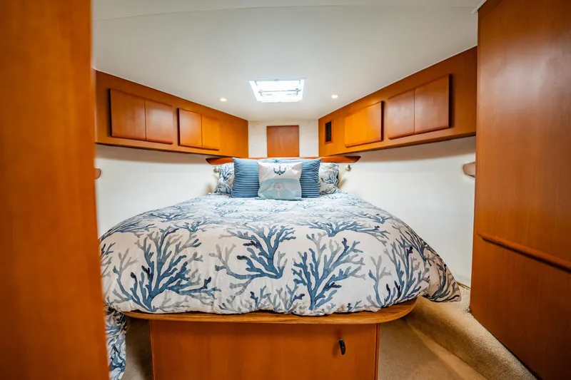 Slide: The Image of Cozy cabin bedroom in 2001 Post 42 yacht with nautical-themed bedding and wooden cabinetry. - 24