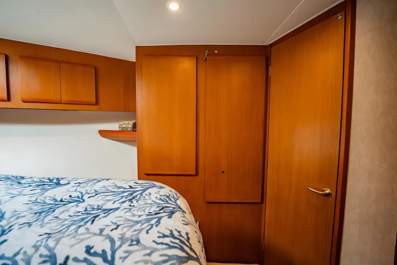 Slide: The Image of Cozy bedroom with wooden cabinets and blue coral-patterned bedding in a 2001 Post 42 model. - 28