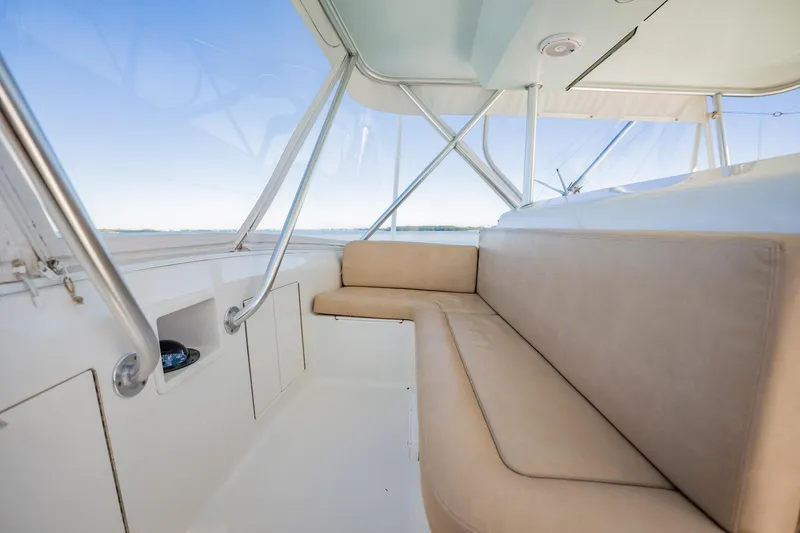 Slide: The Image of Luxurious seating area on a 2001 Post 42 boat, featuring beige cushions and panoramic windows. - 44