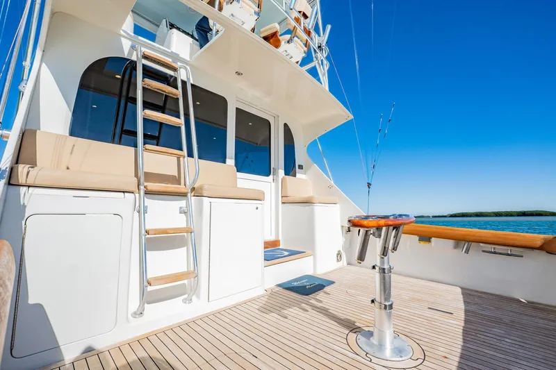 Slide: The Image of Luxury yacht deck with seating, ladder, and fishing rods under clear blue sky. Post 42, 2001. - 62