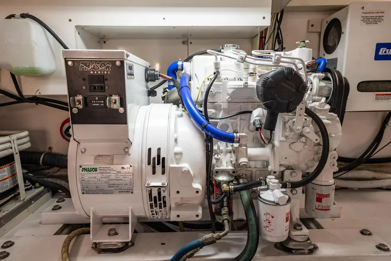Slide: The Image of Phasor Marine generator in engine room, featuring blue hoses and labeled components. - 69
