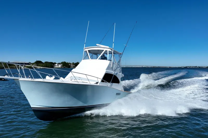 Slide: The Image of 2001 Post 42 yacht cruising on open water under clear blue sky. - 84