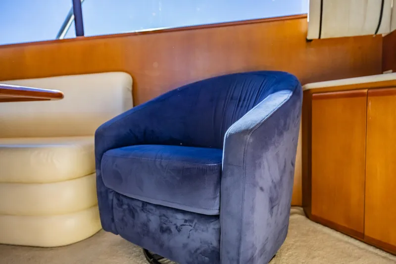Slide: The Image of Blue swivel chair in a 2001 Post 42 yacht interior, with wooden cabinetry and cream seating. - 9