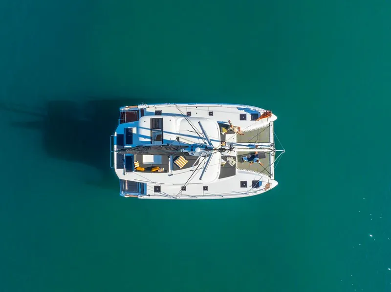 Slide: The Image of Aerial view of 2025 Lagoon 43 catamaran on turquoise water. - 44