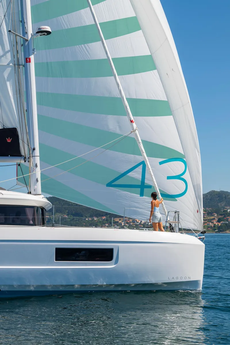 Slide: The Image of 2025 Lagoon 43 sailboat with striped sails on calm water. - 5