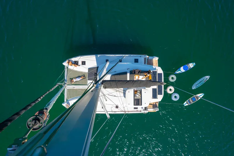 Slide: The Image of Aerial view of 2025 Lagoon 43 catamaran with paddleboards and inflatables in the water. - 7