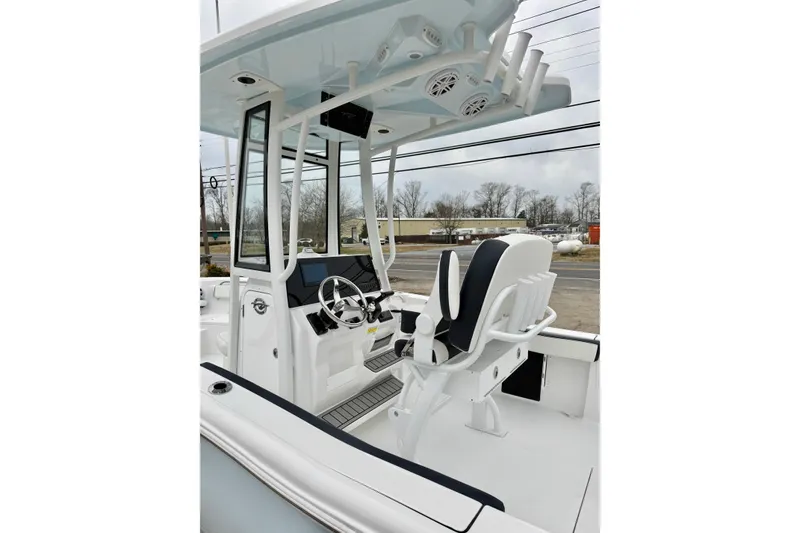 Slide: The Image of 2026 Tidewater 210 CC Adventure boat interior with helm, seating, and T-top. - 17