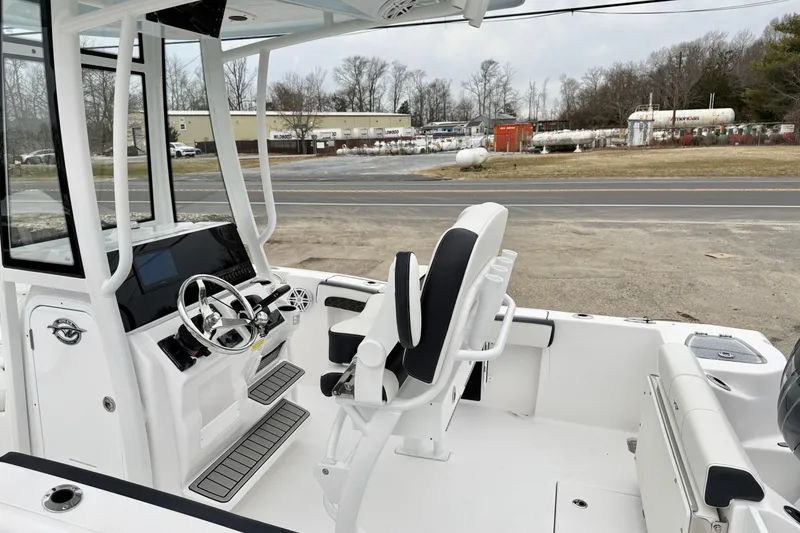 Slide: The Image of 2026 Tidewater 210 CC Adventure boat interior with steering console and seating. - 19