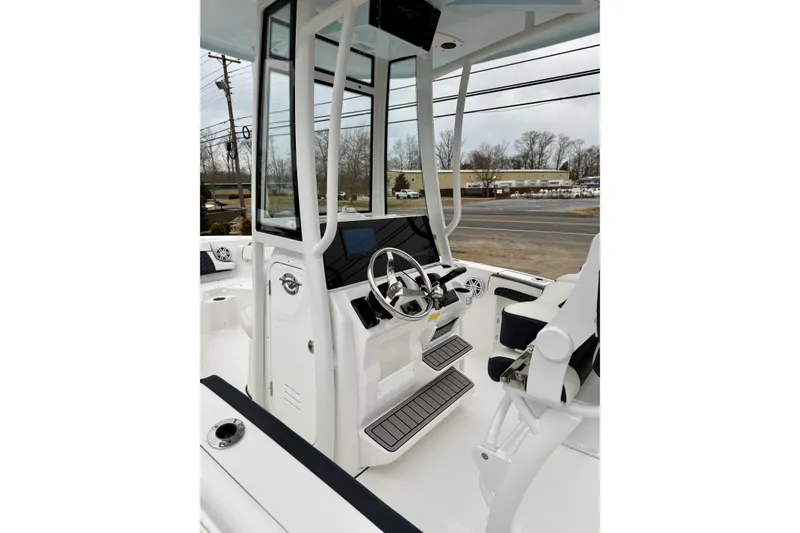 Slide: The Image of 2026 Tidewater 210 CC Adventure boat interior with steering wheel and seating. - 20