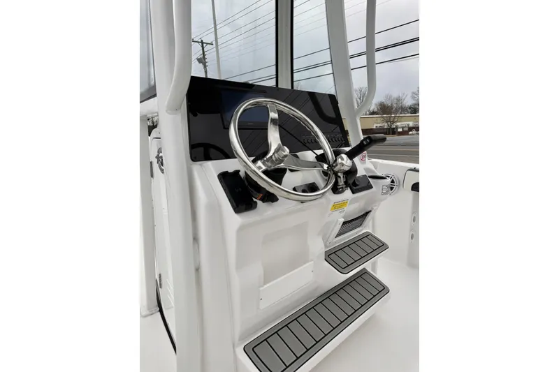 Slide: The Image of 2026 Tidewater 210 CC Adventure boat helm with steering wheel and controls. - 21