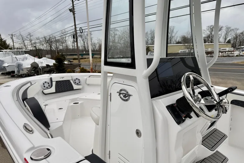 Slide: The Image of 2026 Tidewater 210 CC Adventure boat interior with steering wheel and seating area. - 23