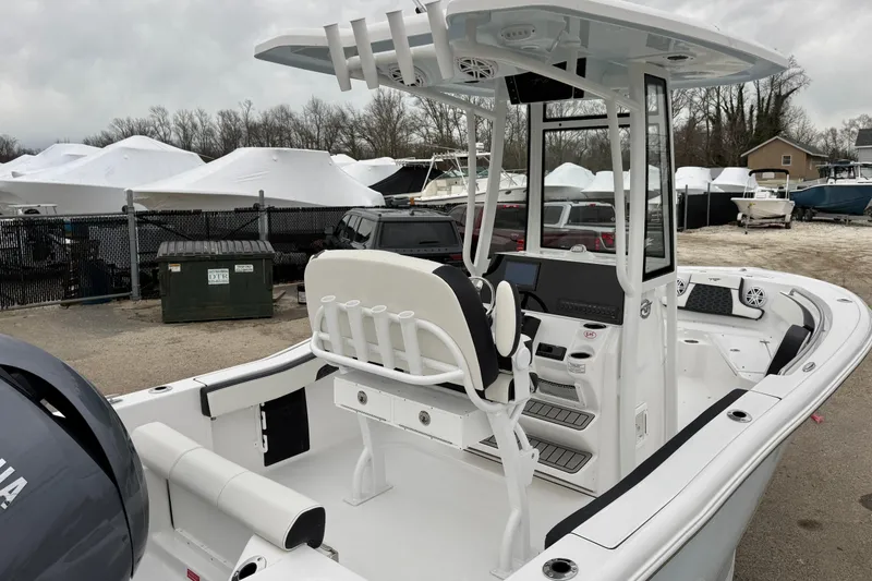 Slide: The Image of 2026 Tidewater 210 CC Adventure boat with modern console and seating, parked outdoors. - 33