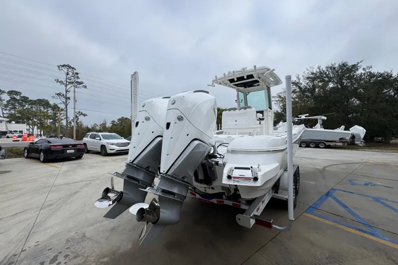 Slide: The Image of 2026 Caymas 281 HB boat with dual engines on a trailer in a parking lot. - 13