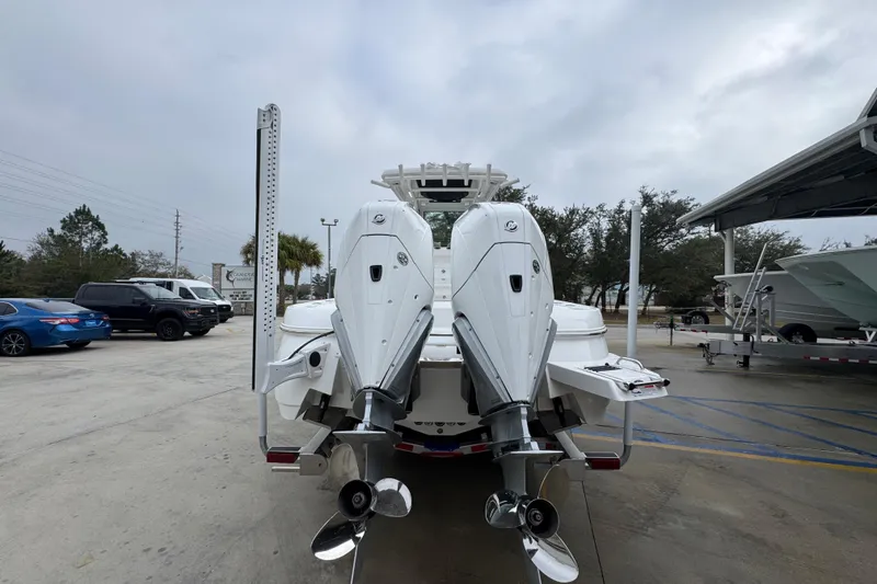 Slide: The Image of 2026 Caymas 281 HB boat with dual outboard motors in a parking area. - 14