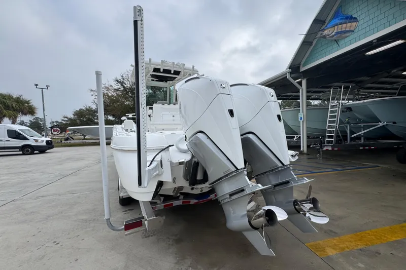 Slide: The Image of 2026 Caymas 281 HB boat with dual outboard motors in a marina setting. - 15